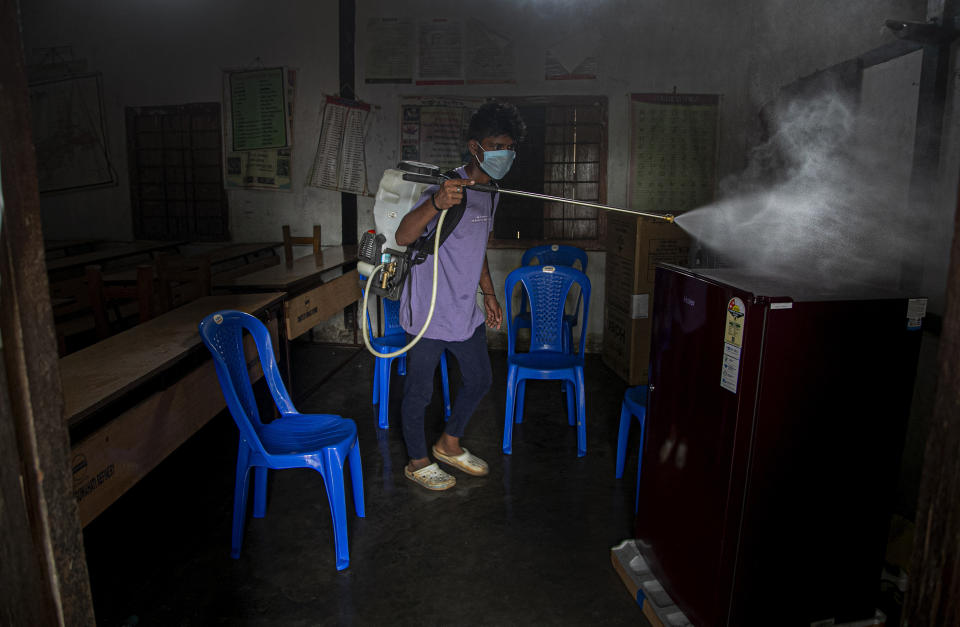 An Indian health worker disinfects a COVID-19 test center in Gauhati, India, Sunday, Sept. 6, 2020. India's coronavirus cases have crossed 4 million, leading the world in new infections and deepening misery in the country's vast hinterlands where surges have crippled the underfunded health care system. (AP Photo/Anupam Nath)