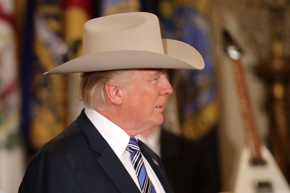 Trump models a Stetson cowboy hat.