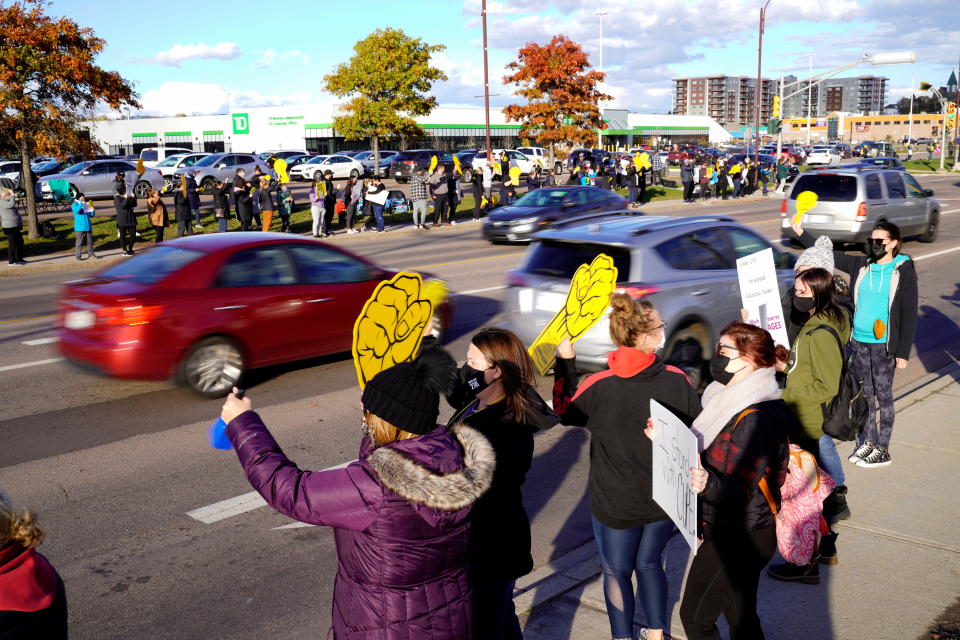 Canadian Union of Public Employees (CUPE) supporters hold up signs along Champlain Street during a strike, in Moncton, New Brunswick, Canada, November 1, 2021. REUTERS/John Morris