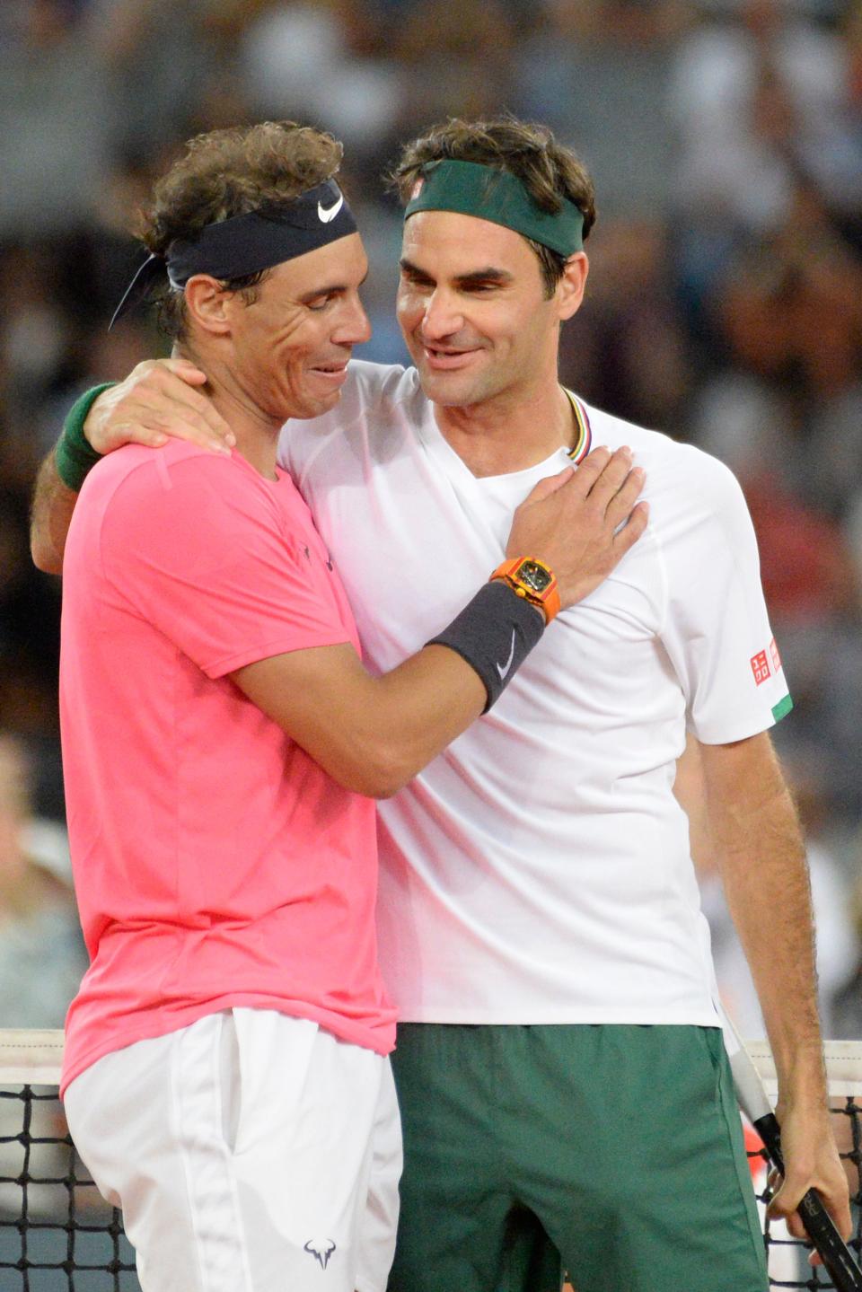 Roger Federer (R) hugs Spain's Rafael Nadal (L) embrace and smile after a match.