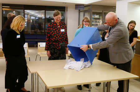 An election official empties ballot box during general election at the polling station in Tallinn, Estonia March 3, 2019. REUTERS/Ints Kalnins