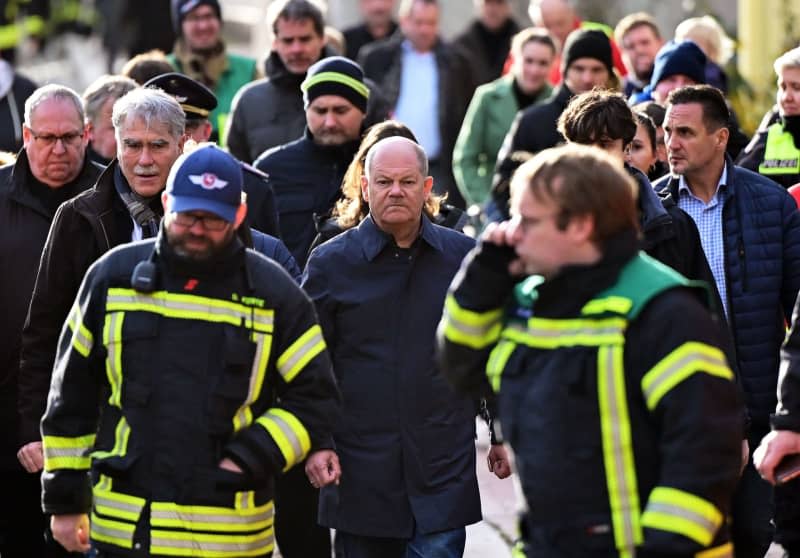 German Chancellor Olaf Scholz (C) walks through the city center with emergency services during his visit to the flooded area at the confluence of the Weser and Aller rivers. Chancellor Olaf Scholz took a sightseeing flight in an air force helicopter to gain an impression of the flooding situation in the north of Lower Saxony. Philipp Schulze/dpa