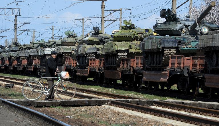 A man stands near a trainload of Ukrainian tanks which are set to leave Crimean peninsula at Gvardeyskoe railway station near the Crimean capital Simferopol on March 31, 2014