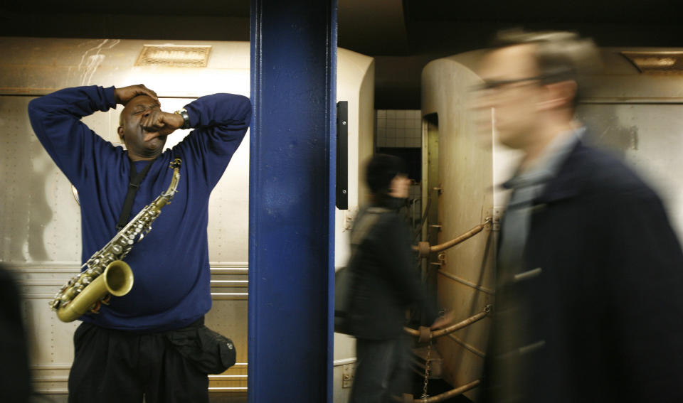 Musician Lew Jordan yawns while taking a break from playing the saxophone for train riders in the subway system of New York April 13, 2007. REUTERS/Lucas Jackson (UNITED STATES)