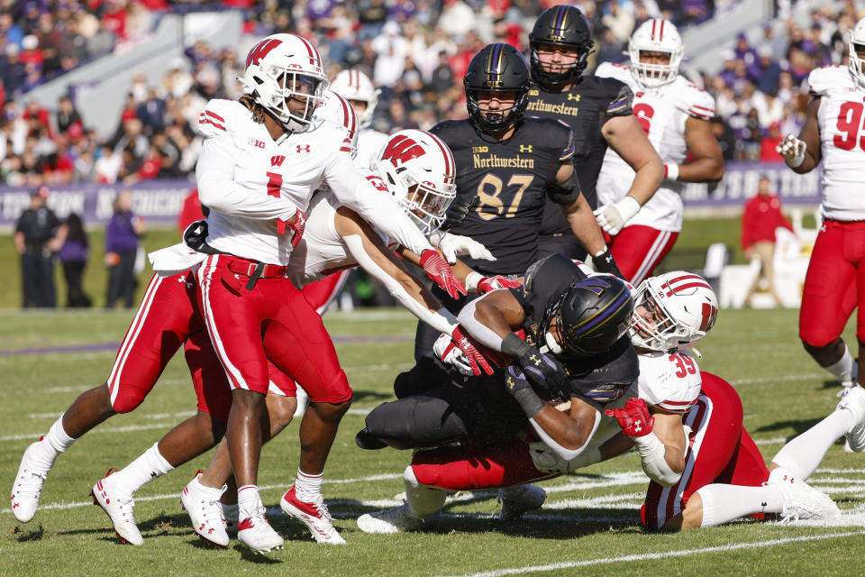 Wisconsin linebacker Tatum Grass (39) tackles Northwestern running back Cam Porter (4) during the first half of an NCAA college football game on Saturday, Oct. 8, 2022, in Evanston, Ill. (AP Photo/Kamil Krzaczynski)