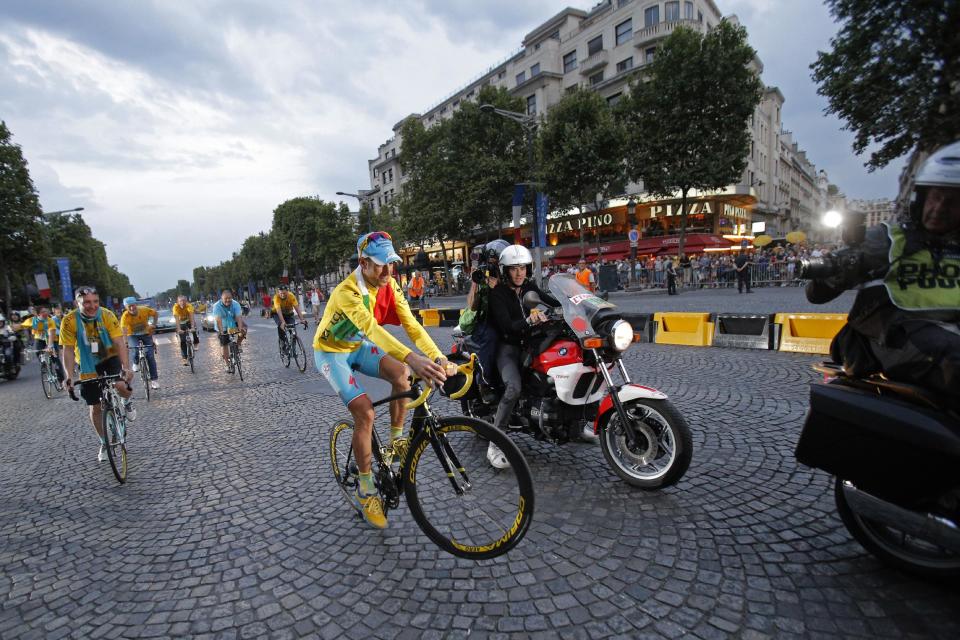 2014 Tour de France cycling race winner Italy's Vincenzo Nibali pulls a wheelie during the team parade of the Tour de France cycling race in Paris, France, Sunday, July 27, 2014. (AP Photo/Christophe Ena)