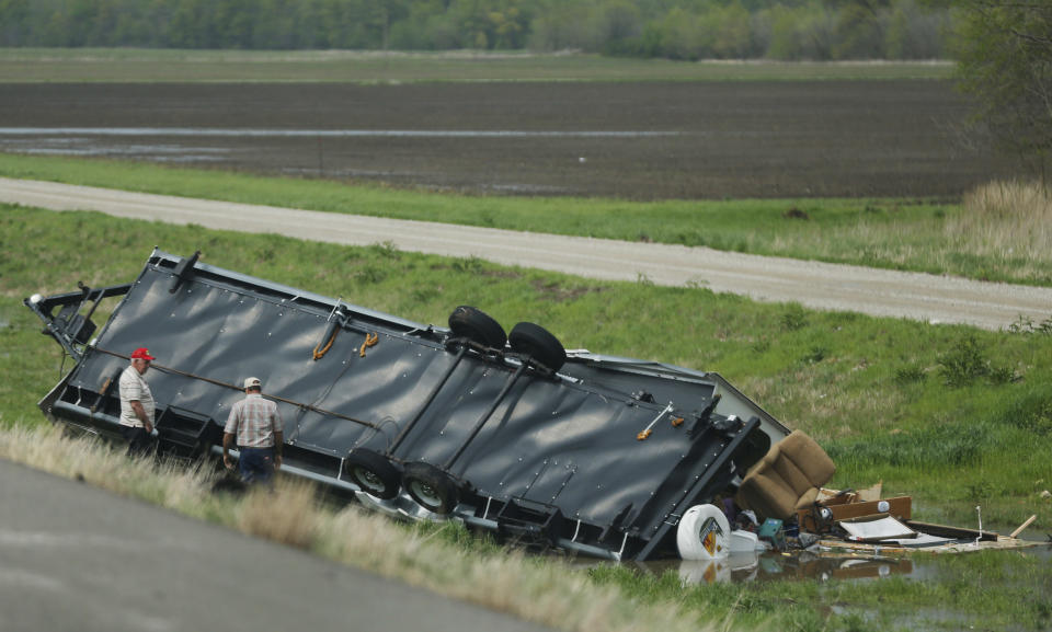 Motorists check out a travel trailer damaged in an accident involving high winds from a severe thunderstorm that passed near Rich Hill, Mo., Sunday, April 27, 2014. (AP Photo/Orlin Wagner)