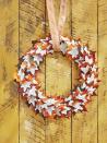 <p>A paper wreath is an incredibly lovely addition to any front door. With leaf shapes galore, this one's perfectly seasonal too.<strong><br></strong></p><p><strong>Make the wreath:</strong> Draw a 3-inch-wide maple leaf shape on a piece of cardboard and cut out to create a stencil. Trace on original pages (or, preferred, photocopied pages) of a vintage book—consider a fall-themed title or mystery novel—and cut out approximately 100 leaves with decorative scissors that have a "torn paper" edge. Attach book page leaves to maple leaves with hot glue. Attach layered leaves to a 16-inch wreath form with hot glue, layering and overlapping them as you go. Hang with burlap ribbon.</p>