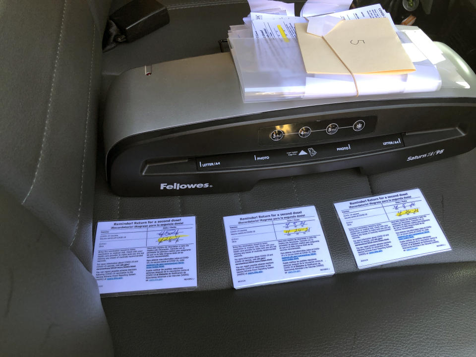 This undated photo provided by the California Department of Alcoholic Beverage Control shows confiscated fraudulent COVID-19 vaccination cards and a lamination machine. A Northern California bar owner was arrested on suspicion of selling fake COVID-19 vaccination cards to several undercover state agents for $20 each. After receiving a tip, undercover agents with the California Department of Alcoholic Beverage Control went to Old Corner Saloon in the city of Clements several times in April and bought fake laminated vaccination cards, officials said. (California Department of Alcoholic Beverage Control via AP)