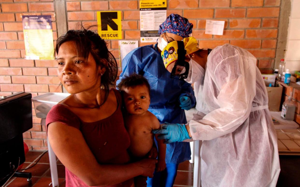 Health care workers check members of an Indigenous community - SCHNEYDER MENDOZA/AFP via Getty Images