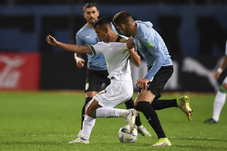 El boliviano Roberto Fernández, a la izquierda, y el uruguayo Federico Valverde luchan por el balón