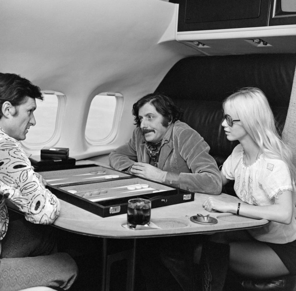 <p>Hugh Hefner (left) enjoys a game of backgammon aboard the Playboy jet in 1971.</p>