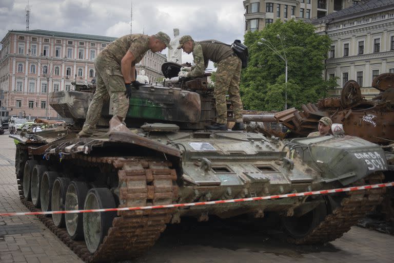 Zapadores inspeccionan un tanque ruso dañado instalado como símbolo de guerra en el centro de Kiev