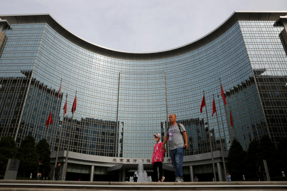 A man with a child walk past Grand Hyatt Hotel near Chang'an Avenue ahead of the 70th anniversary of People's Republic of China in Beijing, China September 19, 2019. Picture taken September 19, 2019. REUTERS/Florence Lo