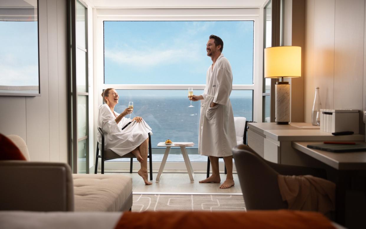 A couple sipping champagne on their Celebrity Cruises balcony