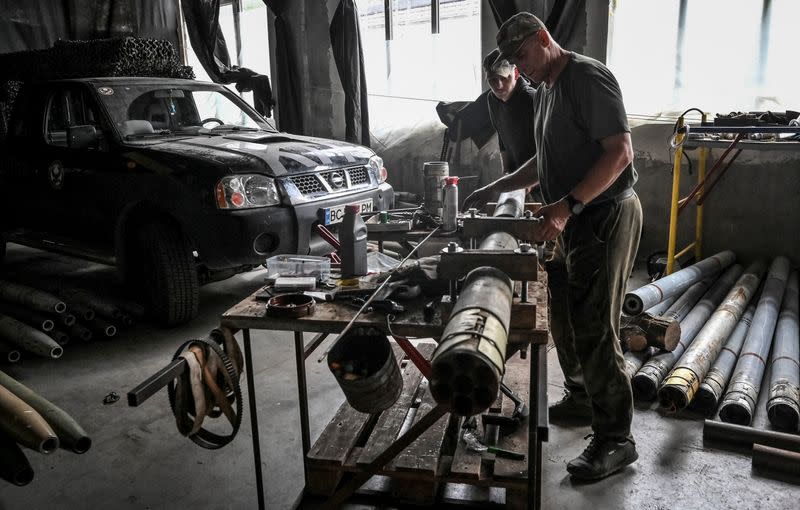 Members of company tactical group "Steppe Wolves" disassemble a shell for a BM-21 Grad multiple launch rocket system to convert it for use with a handmade small MLRS for firing toward Russian troops in Zaporizhzhia region