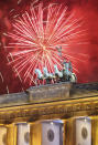 BERLIN, GERMANY - JANUARY 01: Fireworks explode over the Quadriga statue atop the Brandenburg Gate on New Year's Eve on January 1, 2012 in Berlin, Germany. According to the media, up to one million people celebrate the country's biggest New Year's Eve Party. (Photo by Andreas Rentz/Getty Images)