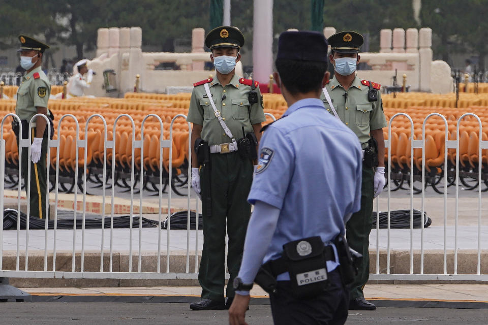Paramilitary police wearing face masks to help curb the spread of the coronavirus stand guard near rows of seat setup on Tiananmen Square in Beijing, Monday, June 28, 2021. China is marking the centenary of its ruling Communist Party this week by heralding what it says is its growing influence abroad, along with success in battling corruption at home. (AP Photo/Andy Wong)