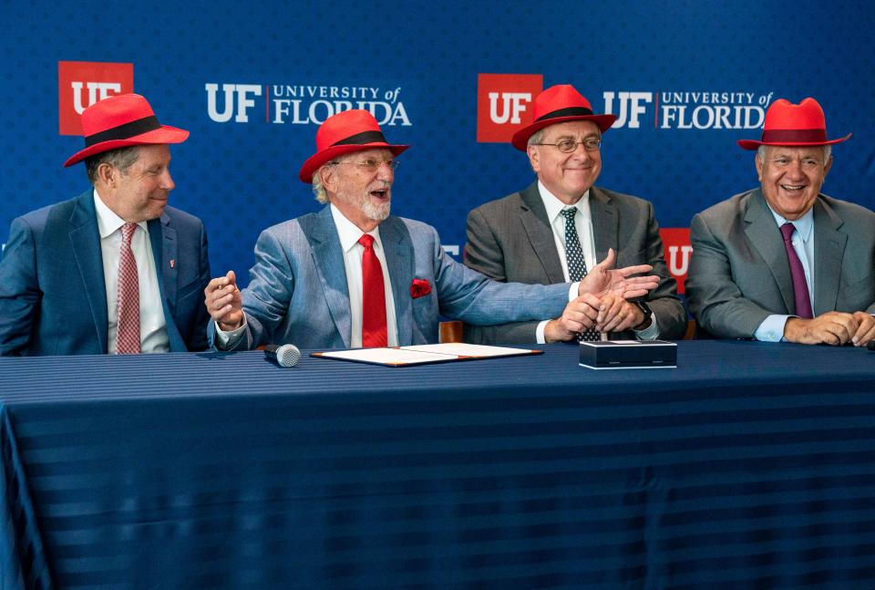 Dr. Dave Nelson, left, listens to Dr. Herbert Wertheim next to then-UF President Kent Fuchs and trustee Mori Hosseini during a ceremony announcing that the Dr. Herbert and Nicole Wertheim Family Foundation would be donating $100 million to the UF Scripps Biomedical Research in Jupiter in 2022.