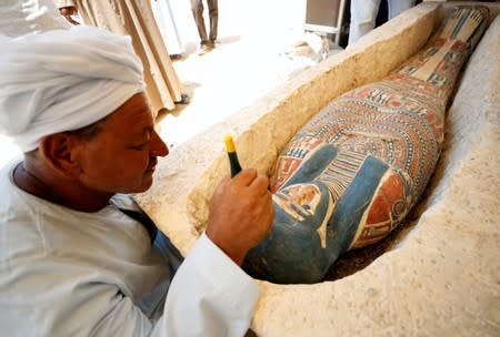 An archeological worker displays a sarcophagus that was discovered near the King Amenemhat II pyramid, south of Cairo