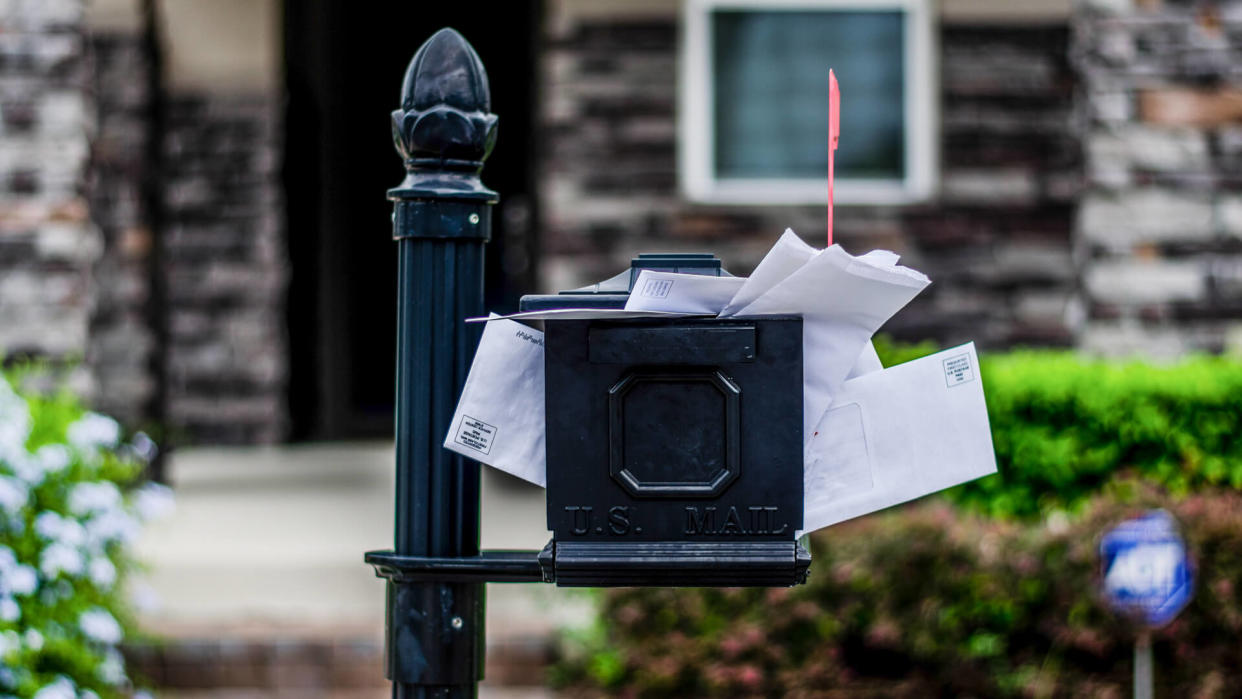 Mailbox with bills overflowing.