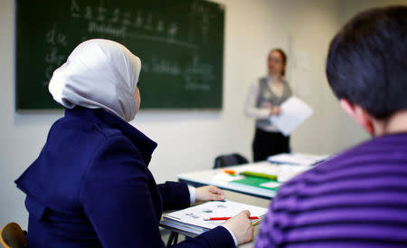 Migrants attend a lesson at the "institute for intercultural communication" in Berlin, Germany, April 13, 2016. REUTERS/Hannibal Hanschke