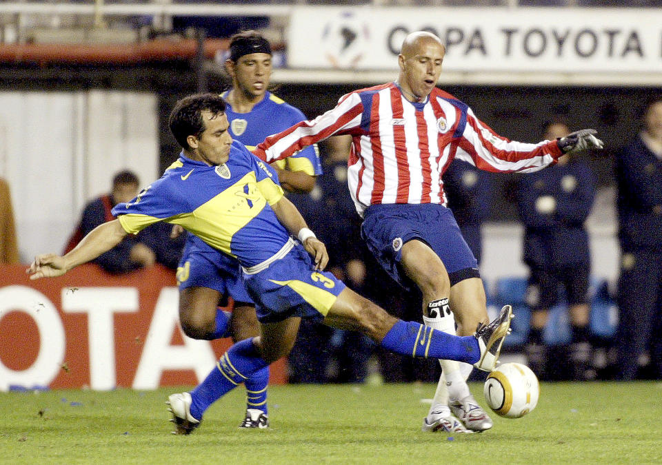 Guadalajara's Bautista and Boca Juniors' Rodriguez fight for ball during Libertadores Cup soccer match in Buenos Aires.  Guadalajara's Adolfo Bautista (R) and Boca Juniors' Morel Rodriguez (L) fight for the ball during their Libertadores Cup soccer match in Buenos Aires June 14, 2005. REUTERS/Santiago Pandolfi