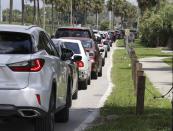 Cars wait in line for COVID-19 testing at Barnett Park, in Orlando, Fla., Thursday, July 29, 2021. The line stretched through the park for more than a mile to the entrance to the Central Florida Fairgrounds. Orange County is under a state of emergency as coronavirus infections skyrocket in Central Florida. The Barnett Park site is testing 1,000 people a day and has closed early in recent days due to reaching capacity. (Joe Burbank/Orlando Sentinel via AP)