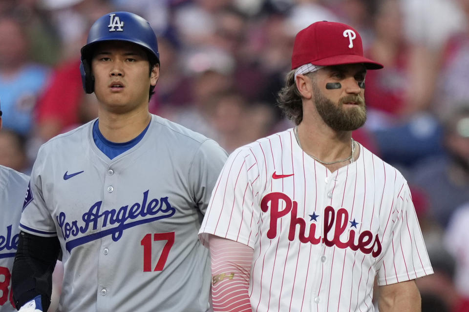 Los Angeles Dodgers' Shohei Ohtani, left, and Philadelphia Phillies' Bryce Harper stand near first base during the third inning of a baseball game, Tuesday, July 9, 2024, in Philadelphia. (AP Photo/Matt Slocum)