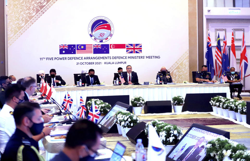 In this photo released by Malaysia Defense Ministry, Malaysian Defense Minister Hishammuddin Hussein, center rear, speaks during the opening of the Five Power Defense Arrangements (FPDA) meeting in Kuala Lumpur, Malaysia, Thursday, Oct. 21, 2021. Australia and Britain are defending their nuclear submarine deal with the U.S. amid concerns it could escalate tensions in the region and spark an arms race. (Malaysia Defense Ministry via AP)