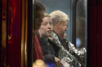 People receive medical attention on a bus after part of the ceiling at the Apollo Theatre on Shaftesbury Avenue collapsed in central London December 19, 2013. Emergency services said nearly 90 people were injured on Thursday when part of the ceiling collapsed during a performance at the packed London theatre, bringing the city's West End entertainment district to a standstill. REUTERS/Neil Hall (BRITAIN - Tags: DISASTER ENTERTAINMENT TPX IMAGES OF THE DAY)