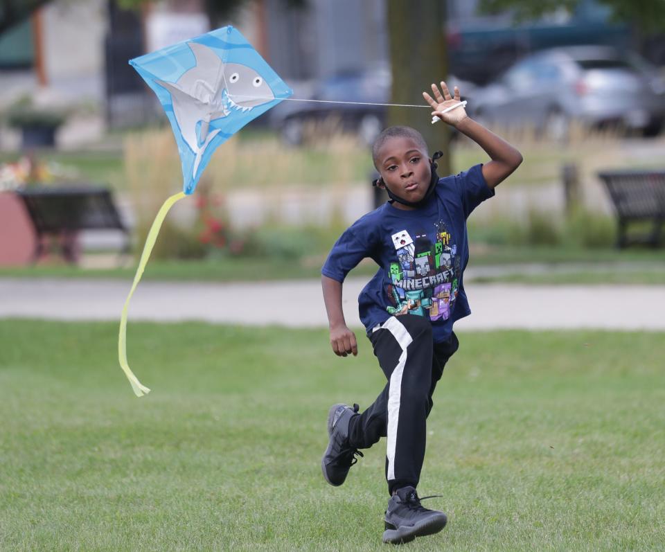 LaVontae Malone, 7, who was with his father, Mario Malone, runs to get his kite in the air during the Kite Giveaway at Johnsons Park on West Fond du Lac Avenue in Milwaukee on Saturday, Sept. 5, 2020. The event, in partnership with Neu-Life, Walnut Way Conservation Corp. and Running Rebels, featured free kites and other activities to inspire healthy ways to get outdoors safely.