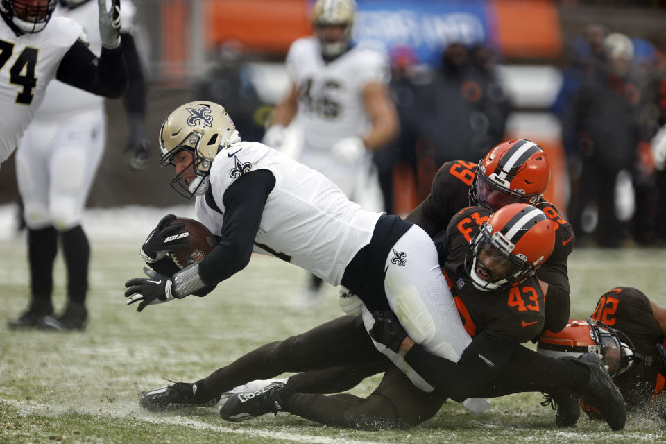New Orleans Saints tight end Taysom Hill (7) pulls Cleveland Browns defenders and falls into the end zone for an 8-yard rushing touchdown during the second half of an NFL football game, Saturday, Dec. 24, 2022, in Cleveland. (AP Photo/Ron Schwane)