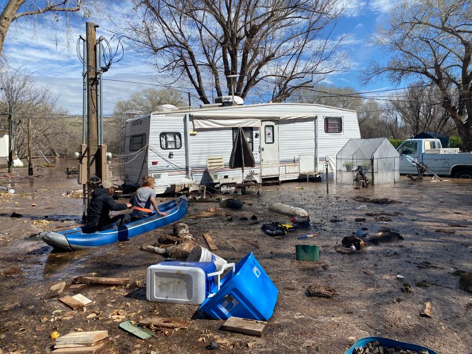 A neighbor rows Laura Carris to her home, which is completely surrounded by floodwaters, at the Wagon Wheel Trailer Ranch in Camp Verde on March 22, 2023.