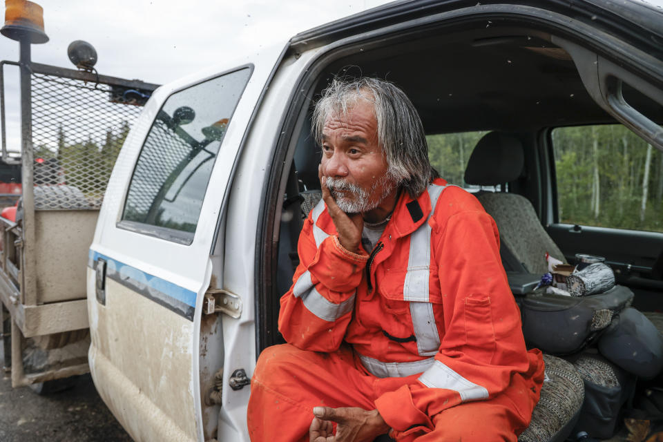 Keith Swirlle rests in his truck while directing traffic from Yellowknife in Fort Providence, N.W.T., Thursday, Aug. 17, 2023. THE CANADIAN PRESS/Jeff McIntosh