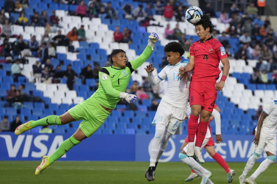 El arquero de Honduras, Juergen García, a la izquierda, busca despejar un cabezazo de Choi Seok-hyun de Corea del Sur, a la derecha, durante un partido del Grupo F del Mundial Sub20 en el estadio Malvinas Argentinas de Mendoza, Argentina, jueves 25 mayo, 2023. (AP Foto/Natacha Pisarenko)