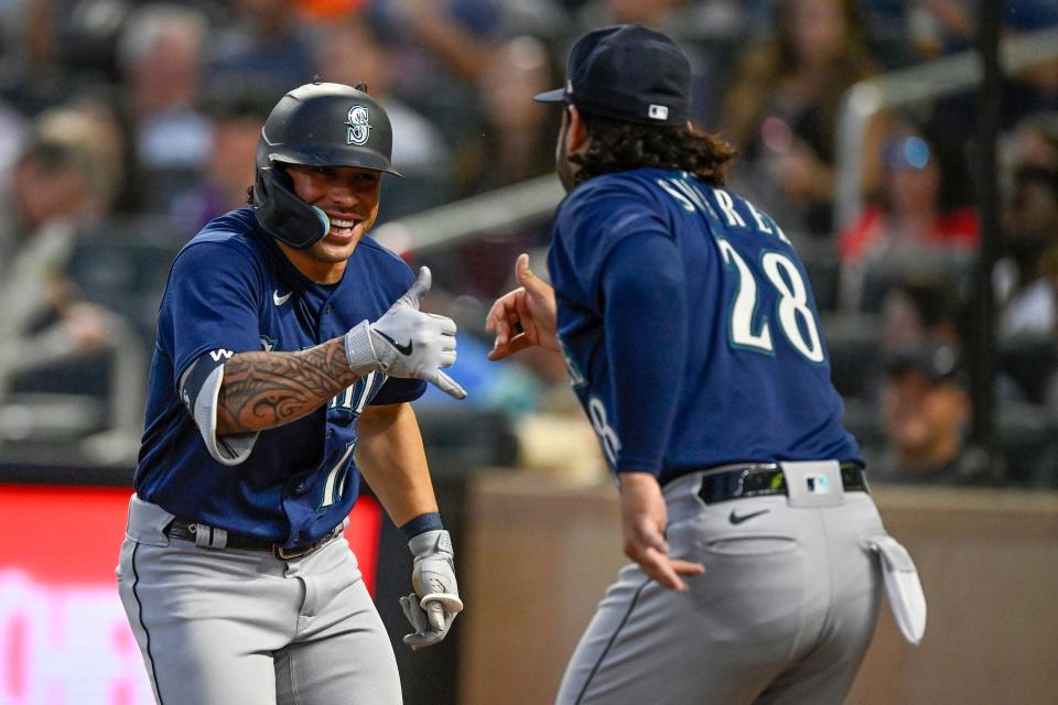 Seattle Mariners infielder Kolten Wong (16) celebrates his pinch-hit two-run home run against the Minnesota Twins with infielder Eugenio Suarez (28) during the ninth inning at Target Field.