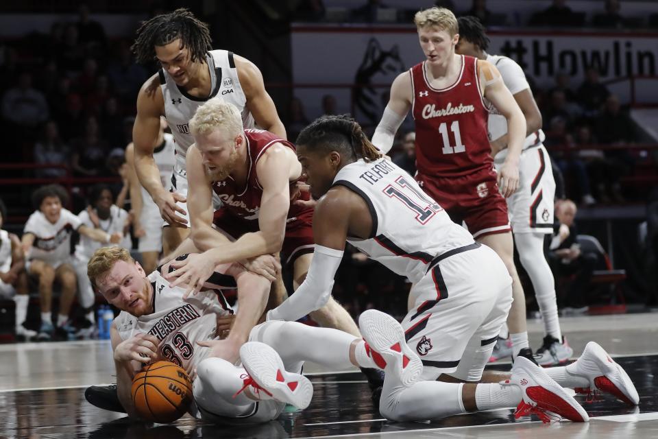 Charleston's Dalton Bolon, top center, battles Northeastern's Chris Doherty (33) and Jahmyl Telfort (11) for a loose ball during the first half of an NCAA college basketball game, Saturday, Jan. 21, 2023, in Boston. (AP Photo/Michael Dwyer)