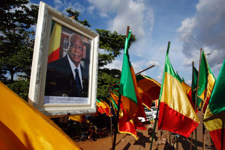 Malian flags are seen near a picture of Ibrahim Boubacar Keita, President of Mali and candidate for Rally for Mali party (RPM), in Bamako, Mali July 24, 2018. REUTERS/Luc Gnago