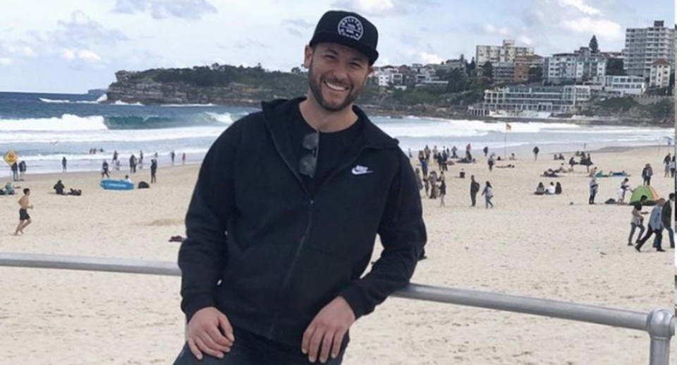 Adalbert Hutter, who was shocked to learn of his property manager's decision to move into his home while he was overseas, can be seen smiling wearing a black cap and jumper in front of Bondi beach.