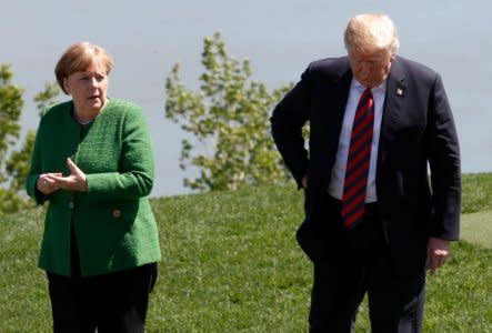 FILE PHOTO: Germany's Chancellor Angela Merkel talks with U.S. President Donald Trump at a family photo session with the leaders of the G-7 summit in Charlevoix, Quebec, Canada, June 8, 2018. REUTERS/Yves Herman/File Photo