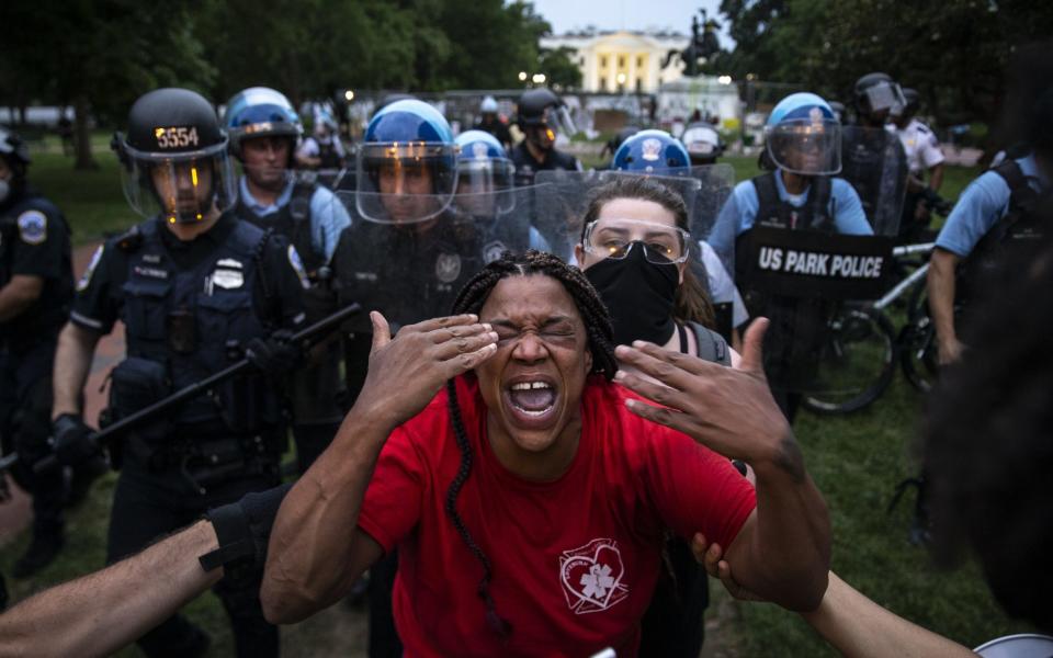 A woman reacts to being hit with pepper spray as protesters clash with Park Police after they attempted to pull down the statue of Andrew Jackson in Lafayette Square near the White House - Tasos Katopodis /Getty Images