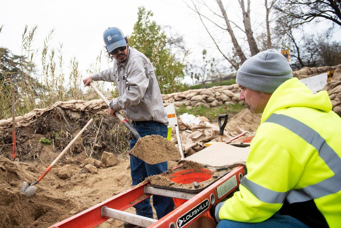 City of Merced wastewater treatment plant employees Trent Rivera, 30, left, and Ed Quaresma, 40, right, fill sandbags to be used along Bear Creek while preparing for upcoming rainstorms in Merced, Calif., on Thursday, March 9, 2023.