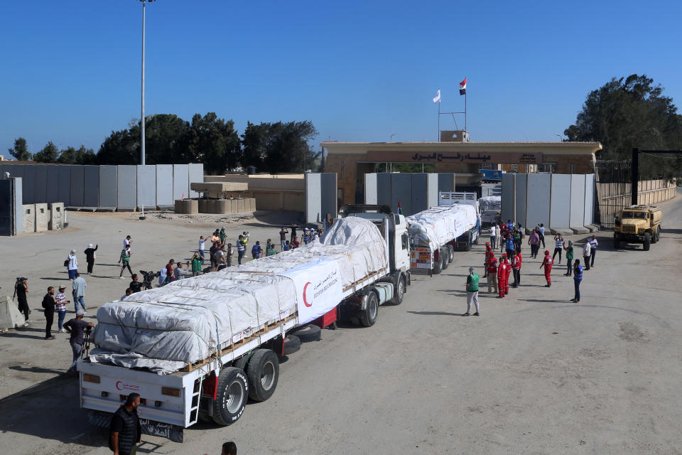 People on the Egyptian side of the Rafah border crossing watch as a convoy of lorries carrying humanitarian aid crosses to the Gaza Strip on October 21, 2023.