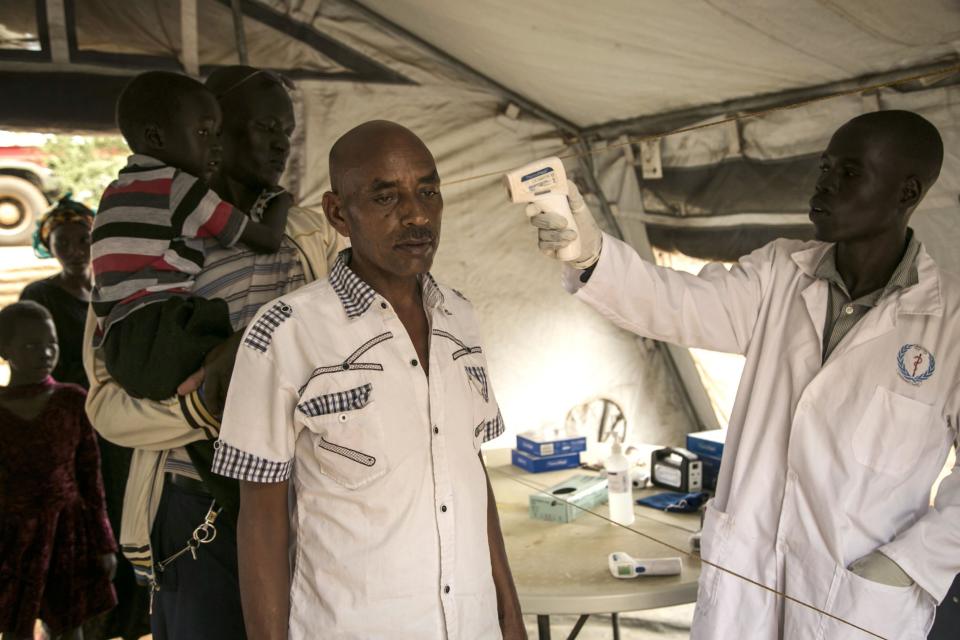 A health worker checks the fever of travelers coming across South Sudan's Nimule border town from Uganda on June 19 (AFP/Getty Images)