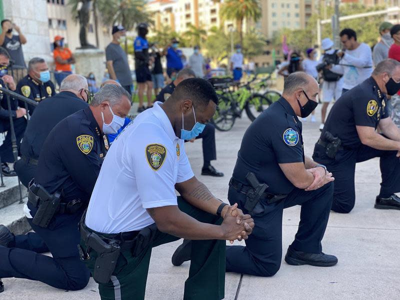  對於美國近日的種族衝突抗爭活動，有警察以單膝下跪的方式表示聲援。（翻攝自推特@RRamosWPLG）