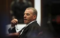 State prosecutor Gerrie Nel gestures as he cross-examines Olympic and Paralympic sprinter Oscar Pistorius during his trial at North Gauteng High Court in Pretoria April 15, 2014. Pistorius is on trial for killing his girlfriend Reeva Steenkamp at his suburban Pretoria home on Valentine's Day last year. He said he mistook her for an intruder. REUTERS/Siphiwe Sibeko (SOUTH AFRICA - Tags: CRIME LAW)