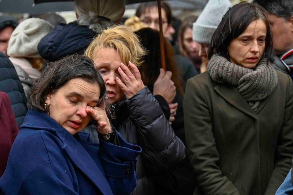 Mourners stand outside the headquarters of Charles University on Friday, Dec. 22, 2023, after a mass shooting in Prague, Czech Republic.