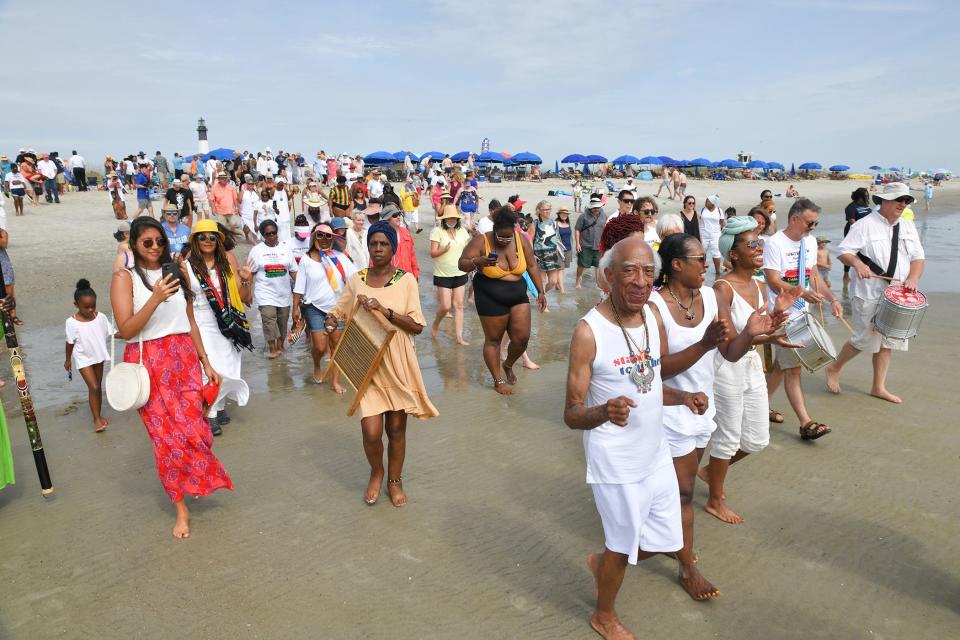 Hundreds of gatherers head into the water during Tybee Island Juneteenth Celebration.