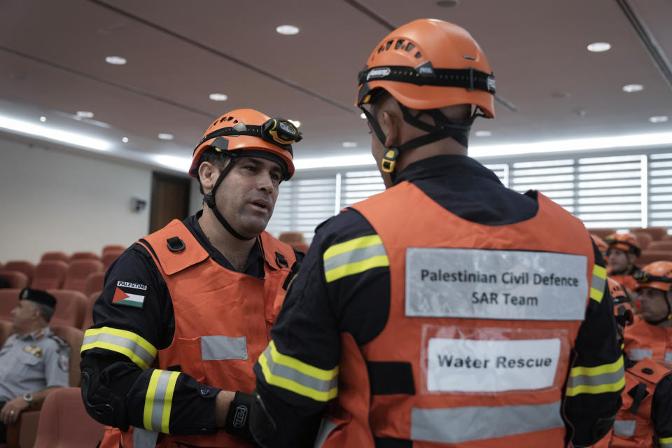 Palestinian civil defense team members listen to a briefing before leaving for a mission to assist flood-stricken Libya, in the West Bank city of Ramallah, Wednesday, Sept. 13, 2023. Palestinian medics and civil defense forces are headed to Libya to join relief and assistance efforts for victims affected by the cyclone that devastated the country. (AP Photo/Majdi Mohammed)